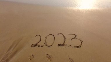 2023 gün batımında dalgalar tarafından kumlara yazıldı..