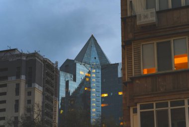 Geceleri Almaty şehrinde farklı tipte binalar, Kazakistan.