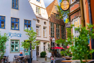 Bremen, Almanya - 26 Eylül 2023. Bremens Bursunda renkli binalar ve açık kafe.