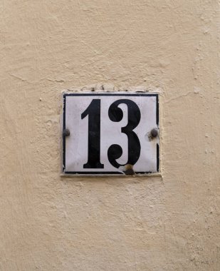 Açık renkli bir duvarda 13 numaralı plaka..