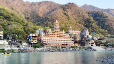 Tera manzil tapınağı ve Rishikesh Hindistan 'daki Ganga nehrinde renkli rafting botu..