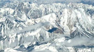 Yüksek irtifadan çekilen, kar kaplı Pamir dağlarının çarpıcı hava manzarası. Ufuk boyunca uzanan engin, engebeli zirveler bu uzak Orta Asya manzarasının dramatik güzelliğini gözler önüne seriyor..