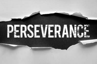 Yırtık kağıdın altında cesur ve sıkıntılı mektuplarla ortaya çıkarılmış bir kelime. Kararlılık, dayanıklılık, dayanıklılık, dayanıklılık, zihinsel güç, hedef belirleme ve motivasyon için sembolik konsept