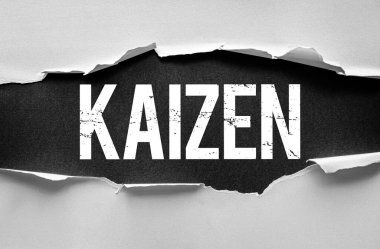 KAIZEN kelimesi yırtık kağıdın altında kaba, desenli bir şekilde belirir. Sürekli iyileşme, zayıf yönetim, iş akışı optimizasyonu ve kişisel veya iş büyüme zihniyeti sembolü