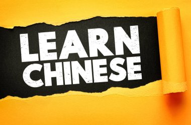 Çince LeARN ifadesinin yer aldığı kavramsal görüntü, siyah bir arkaplanda yırtık sarı kağıdın altında ortaya çıktı. Kalın beyaz sıkıntılı metin dil öğrenmesini ve kültürel eğitimi teşvik ediyor