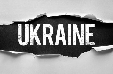 UKRAINE kelimesi yırtık kağıdın arkasında belirir, vahiyleri ya da doğuşları simgeler. Grunge tipografisi ham, etkili bir ton ekler - politika, coğrafya veya kimlik teması için idealdir