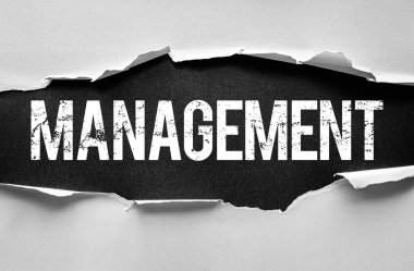 Yırtık kağıt, manastır kelimesini kalın ve sıkıntılı harflerle açıklıyor. Yüzeyin altında gizlenmiş liderlik, organizasyon ve iş stratejilerini sembolize ediyor.