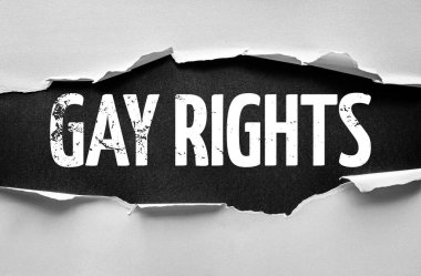 Yırtık kağıt, sıkıntılı blok harflerinde GAY hakları, savunuculuğu, farkındalığı ve LGBTQ + eşitliği, adalet ve toplumsal kabul için devam eden mücadeleyi temsil eden cesur kelimeleri ortaya koyuyor.