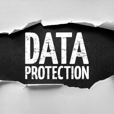 DATA PROTECTION kelimelerini dokulu bir arka planda cesur ve sıkıntılı bir tipografi ile açıklayan yırtık kağıt, güvenliği, mahremiyeti, bilgiyi korumayı ve yönetmeliklere uymayı simgeliyor