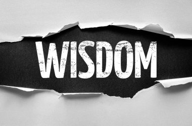 Torn paper reveals the bold word WISDOM in distressed typography, symbolizing knowledge, insight, and understanding emerging from beneath the surface