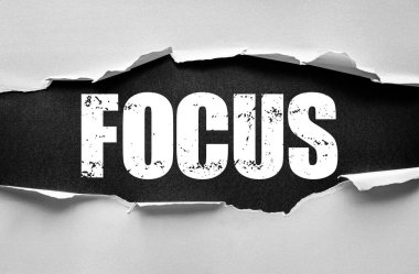 Yırtılmış kağıt altında kalın bir kelime olan FOCUS 'u ortaya çıkarıyor. Konsantrasyonu, kararlılığı, verimliliği, farkındalığı, dikkati, motivasyonu, berraklığı sembolize eden ve hedeflere bağlı kalmayı sembolize eden konsept görüntü