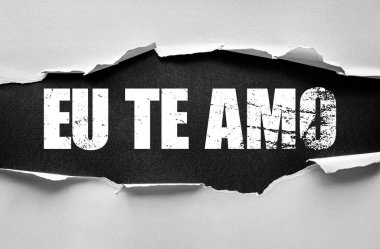 Yırtık kağıt, kederli grunge yazı tipiyle AB TE AMO 'nun cesur sözlerini ortaya koyuyor. Romantik Portekizce 'de 