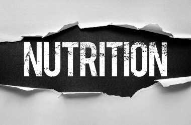 Kelime NUTRITION yırtık kağıt etkisi ile ortaya çıkan büyük harflerle. Sağlıklı yeme, diyet, sağlık, gıda, vitamin, denge ve yaşam tarzını sembolize eden kavramsal görüntü