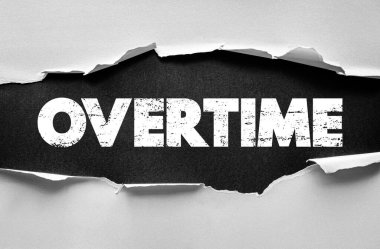 Yırtık kağıt üzerinde fazla mesai ifadesi. İş, kariyer ve iş stresi, ekstra saatler, çalışan hakları, iş ve motivasyon konuları için finans kavramı