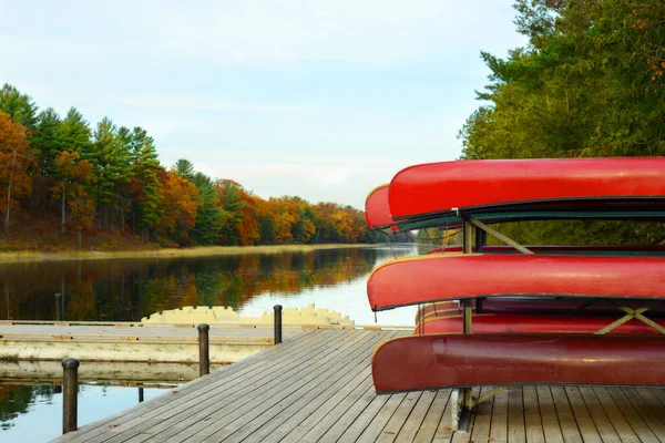 秋には旧水路川のドックに赤いカヌーのラックがあります — ストック写真