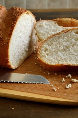 closeup sesame seed loaf of bread on cutting board