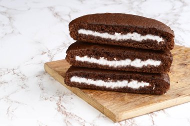 stack of chocolate cream cake slices on cutting board