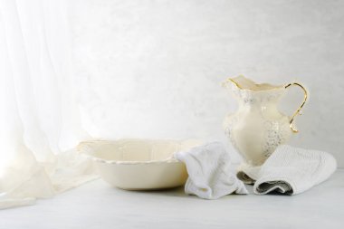 Pencereye yakın eski bir leğen ve sürahi.