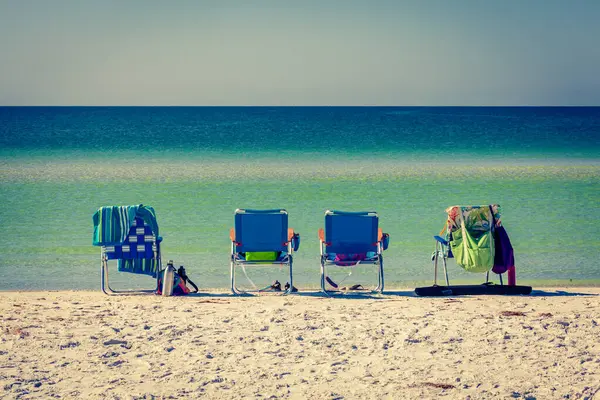 背景にあるメキシコ湾の穏やかな水とフロリダのビーコンのラウンジチェア ロイヤリティフリーのストック画像