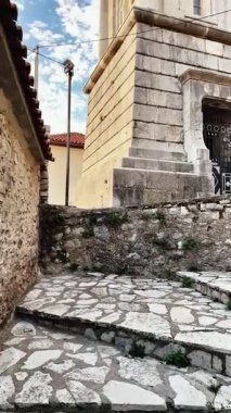 Yunanistan 'ın Arcadia bölgesindeki Dimitsana köyünde saat kulesinin yer aldığı dikey video klip