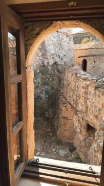 Yunanistan 'ın Mani bölgesindeki Kardamyli kasabasındaki geleneksel bir ev kalesi ve Aziz Spyridon Kilisesi' nin kapısının yer aldığı dikey video klibi