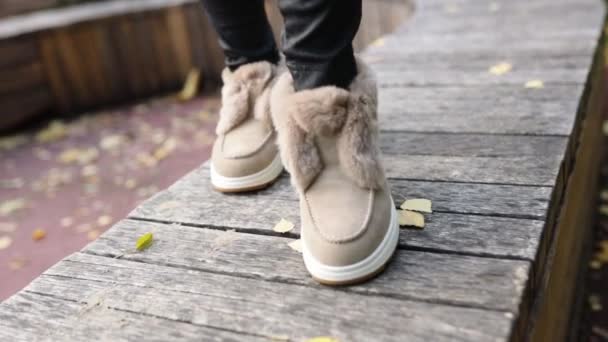 柔らかい光の毛皮と灰色の舗装石のラインストーンとスタイリッシュなトレンディーなベージュ秋の冬の靴 — ストック動画
