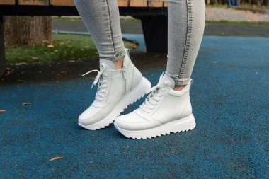 Şehrin caddesinde beyaz ayakkabılı şık bir kadın.