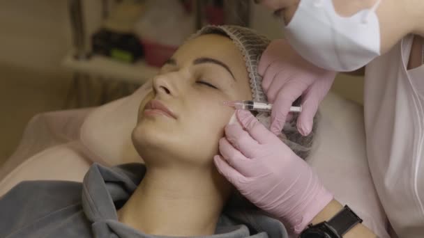 美容室での顔のメソセラピー手順 美容師は若い美人の顔の皮膚に注射 メソセラピー 生物活性化 化粧品学 選択的焦点 — ストック動画