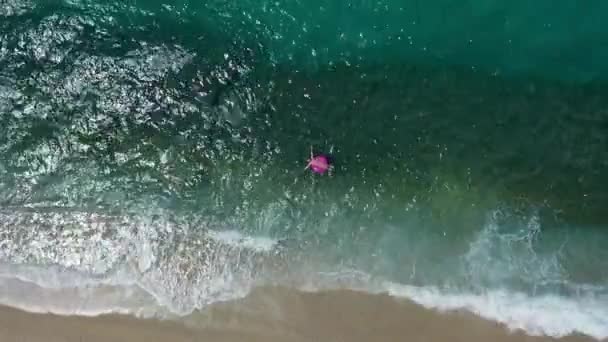 ピンクのスイミングマットレスで泳ぐ長いセクシーな女の子のトップビュー海 ビキニを身に着けています 海の上に表示 リラックスして休暇に楽しみを持っています 高品質4K映像 — ストック動画