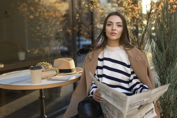 Красива Дівчина Пальто Читає Газету Посміхається Відпочиваючи Відкритому Кафе — стокове фото
