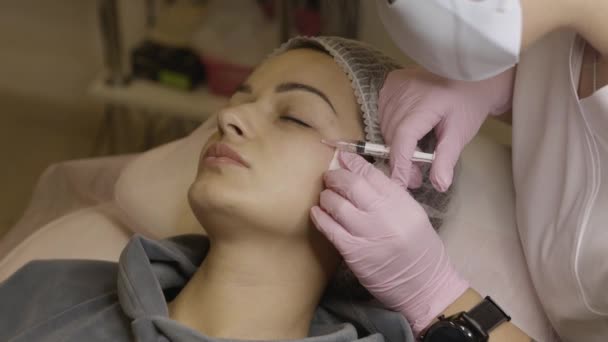 面对美容院的中间治疗程序 美容师医生给一位年轻漂亮的妇女的面部皮肤注射药物 中间治疗 生物修复 化妆品学 有选择的重点 — 图库视频影像
