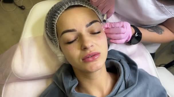 面对美容院的中间治疗程序 美容师医生给一位年轻漂亮的妇女的面部皮肤注射药物 中间治疗 生物修复 化妆品学 有选择的重点 — 图库视频影像