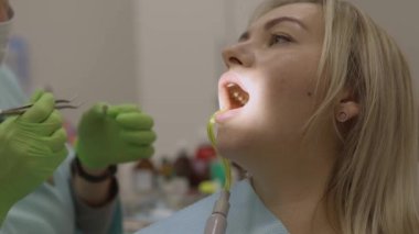 Diş hekimi koltukta oturan hastaya alt dişi matkaplar. Yüksek kalite fotoğraf