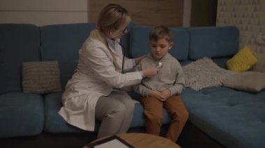Bir aile doktoru evde küçük bir çocuğu muayene ediyor. Pediyatrist kız çocuğu tedavi eder.. 