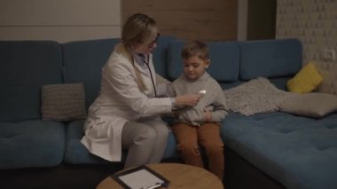 Bir aile doktoru evde küçük bir çocuğu muayene ediyor. Pediyatrist kız çocuğu tedavi eder.. 