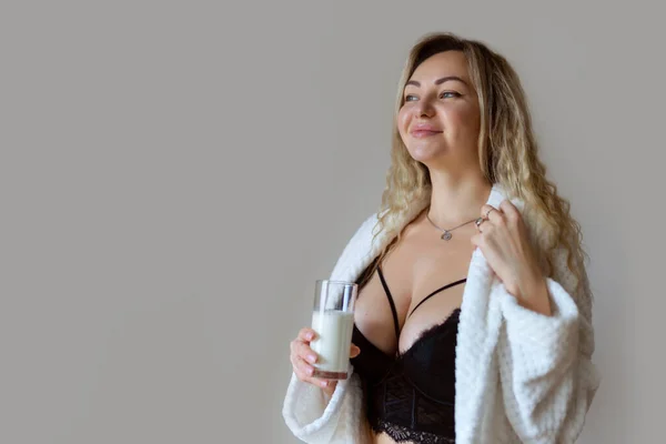体に灰色に分離したミルクを注ぐ黒のランジェリーでセクシーな若い女性 — ストック写真