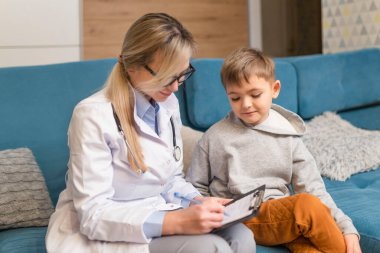 Çocuk doktoru hasta bir çocuğu muayene ediyor. Klinikteki hasta çocuk. Çocukların evde tedavi ettiği virüs..