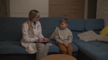 Bir aile doktoru evde küçük bir çocuğu muayene ediyor. Pediyatrist kız çocuğu tedavi eder.. 