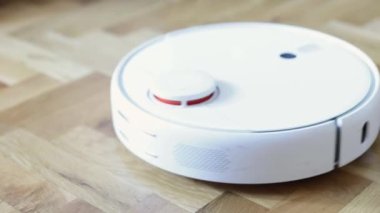 Otomatik Ev Temizliği. Tahta zeminde bir robot süpürge süpürgesi vakumu var. Robot Süpürge Evi Etkin bir şekilde Temizler, Kapanır. Akıllı ev, ev işi. Yüksek kalite 4k görüntü