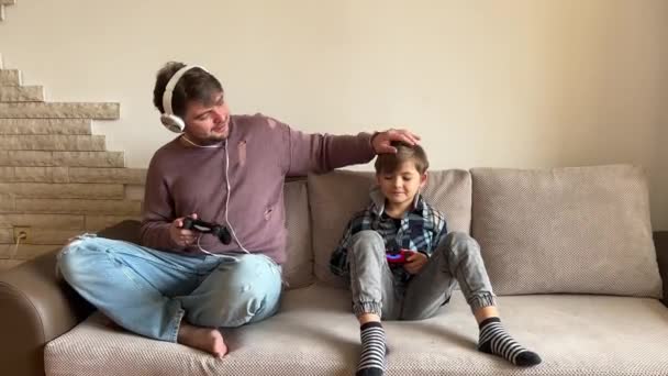 Père Fils Assis Sur Canapé Dans Salon Jouant Jeu Vidéo — Video