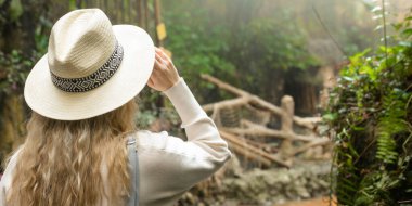 Botanik bahçesi çok çeşitli bitki ve ağaçlarla dolu bir yeşillik vahasıdır. Bir kız bahçede geziniyor, çevresinin güzelliğini içine çekiyor.. 