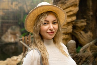 Kameraya bakan şapkalı mutlu bir kadının portresi.