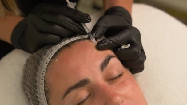 美容院美容师手戴手套 使女性皮肤中的面部老化注射 女人做美容面部美容术 肉毒杆菌毒素胶原蛋白注射 — 图库视频影像