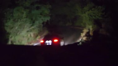 Araba gece hareket eder yağmurda ve dağlık arazide şimşekler çakar. 