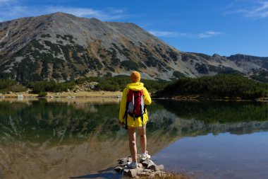 Göl manzarasından hoşlanan kadın turist aktif tatilde sağlıklı yaşam tarzı eko turizminde seyahat ediyor..