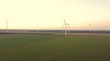 Yükseklerdeki bulutlu gökyüzünde enerji üretimi için güçlü rüzgar türbini çiftliğinin hava manzarası. Rüzgar güç türbinleri sürdürülebilir kalkınma için temiz yenilenebilir enerji üretiyor.