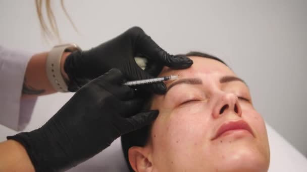美容院美容师手戴手套 使女性皮肤中的面部老化注射 女人做美容面部美容术 肉毒杆菌毒素胶原蛋白注射 — 图库视频影像