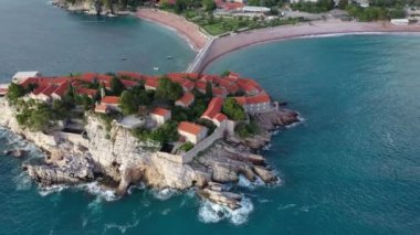 Karadağ 'daki Sveti Stefan tatil beldesi, 4K' lık İHA videosunun etrafındaki şaşırtıcı hava manzarası. Karadağ 'ın küçük eski Sveti Stefan kenti ve tatil beldesi.