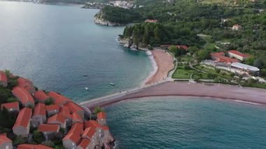 Karadağ 'daki Sveti Stefan tatil beldesi, 4K' lık İHA videosunun etrafındaki şaşırtıcı hava manzarası. Karadağ 'ın küçük eski Sveti Stefan kenti ve tatil beldesi.