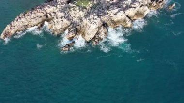 Deniz dalgaları taşlara çarpıyor. 
